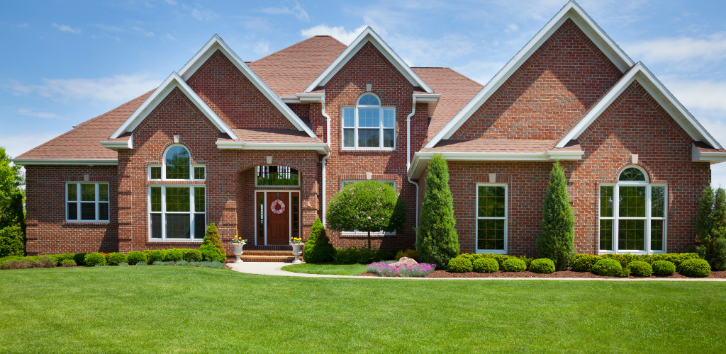 Freshly mowed lawn in front of red brick two-story house